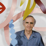 Photograph of Tom Wesselmann behind a laser-cut steel sculpture of a woman