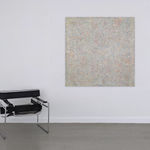 Abstract painting consisting of small marks covering the entire visual field hanging on a wall next to a chair