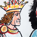 Detail of a tempera painting of a king with long brown hair wearing a gold crown.