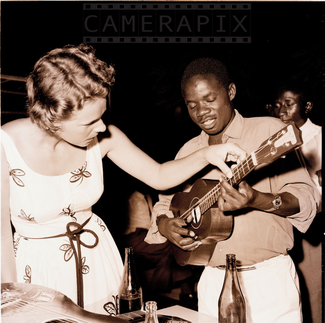Mohamed (Mo) Amin, A Lady Being Shown How to Tune A Guitar By Musician, 1970/1980