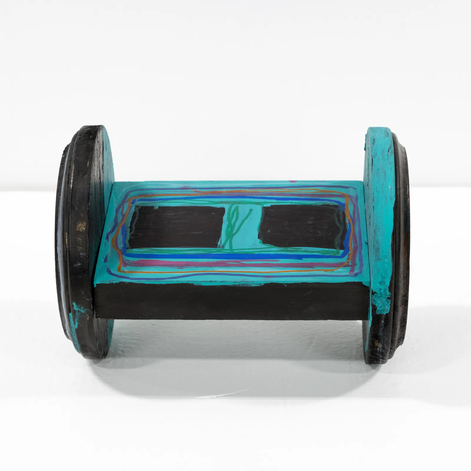 A small wooden sculpture that looks like a hoverboard colored in with marker. 