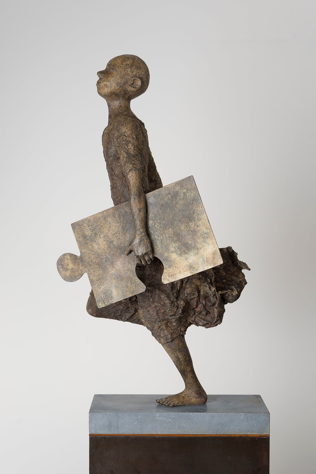 Chaînon manquant lieven d'haese sculpture contemporaine en bronze un garçon courant avec un puzzle sculpture enfant sculpture enfance Art Yi sculpture de jardin conception d'art de jardin galerie d'art à bruxelles