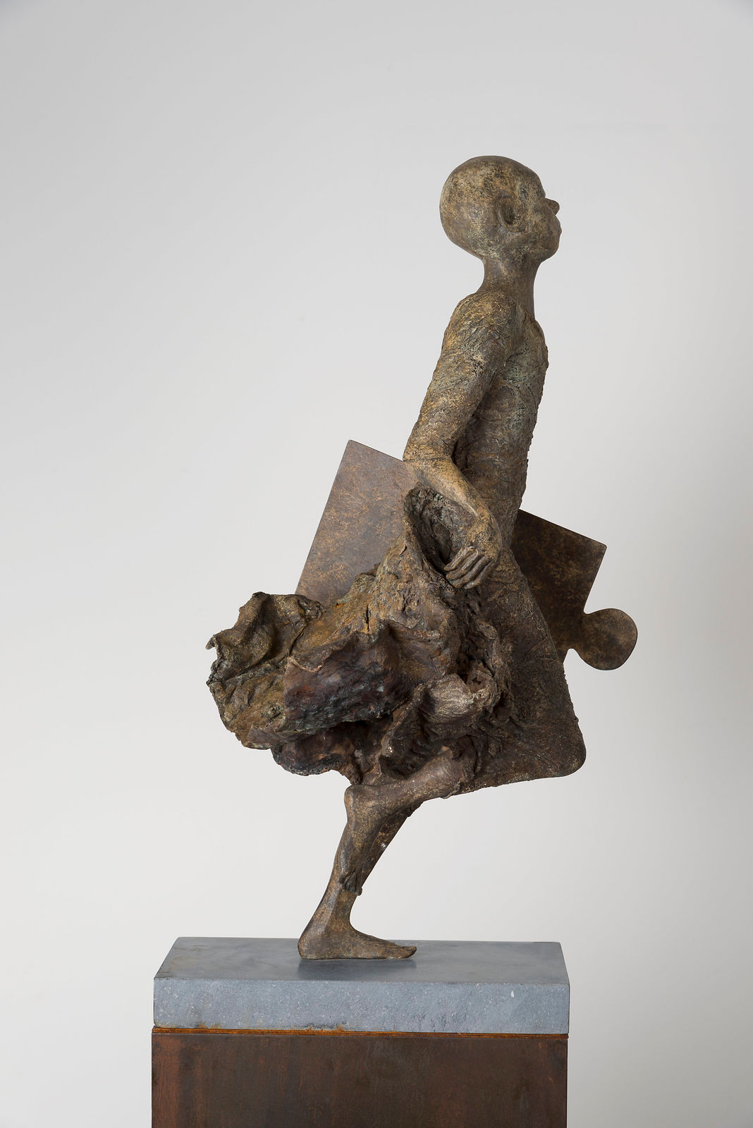 Ontbrekende schakel lieven d'haese hedendaagse bronzen sculptuur een jongen die rent met een puzzel sculptuur kindersculptuur kindertijd Art Yi tuin beeldentuin art design kunstgalerie in brussel
