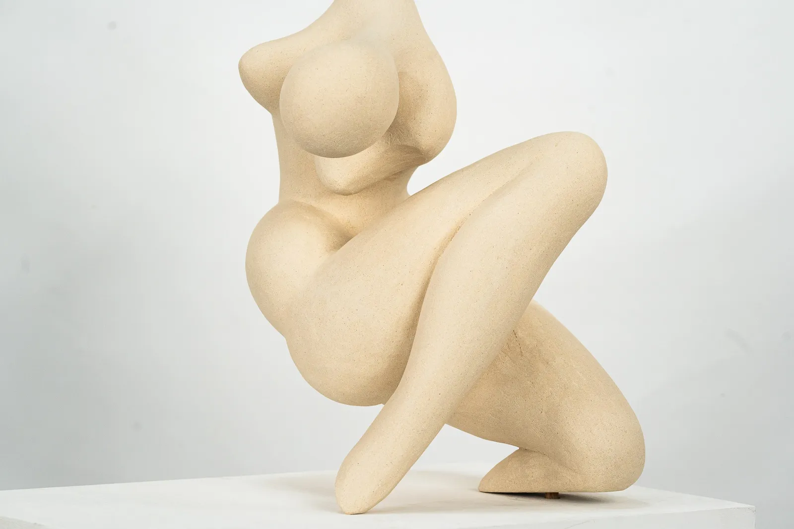 Figurative sculpture in white clay by artist Emilio DiIorio. Crouching figure is No. 2 in artist's Fragmented Aphrodite series.