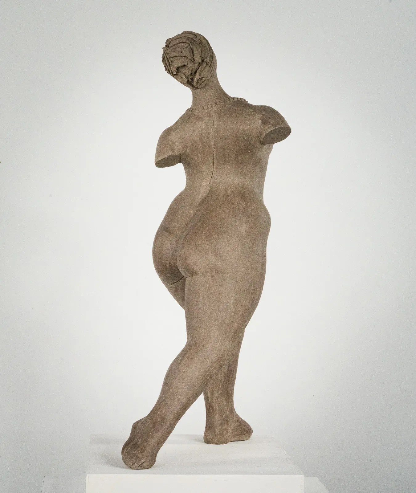 Figurative ceramic sculpture by artist Emilio DiIorio. Female figure is No. 3 in artist's The Dance series in gray clay.