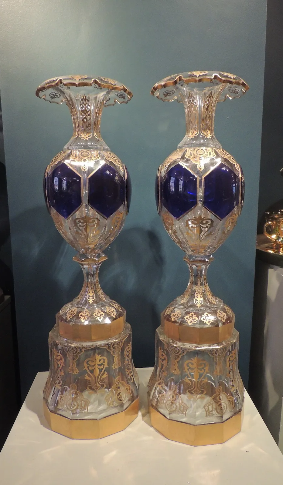 Pair of glass vases on pedestals, decorated in gold and blue