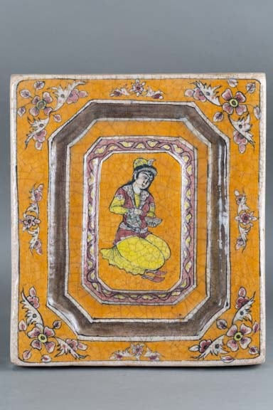 Glazed tile with a kneeling figure on orange background
