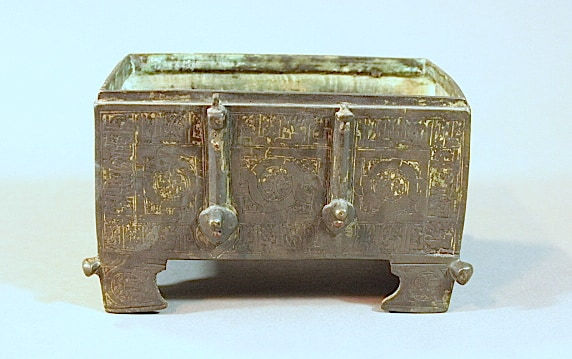 A Khorassan silver and copper inlaid casket base, of rectangular form resting on four feet with prot, 13th Century CE