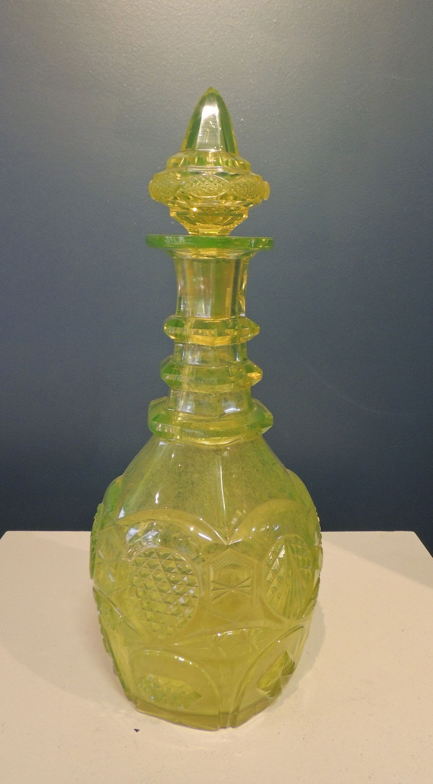 Lidded green glass bottle