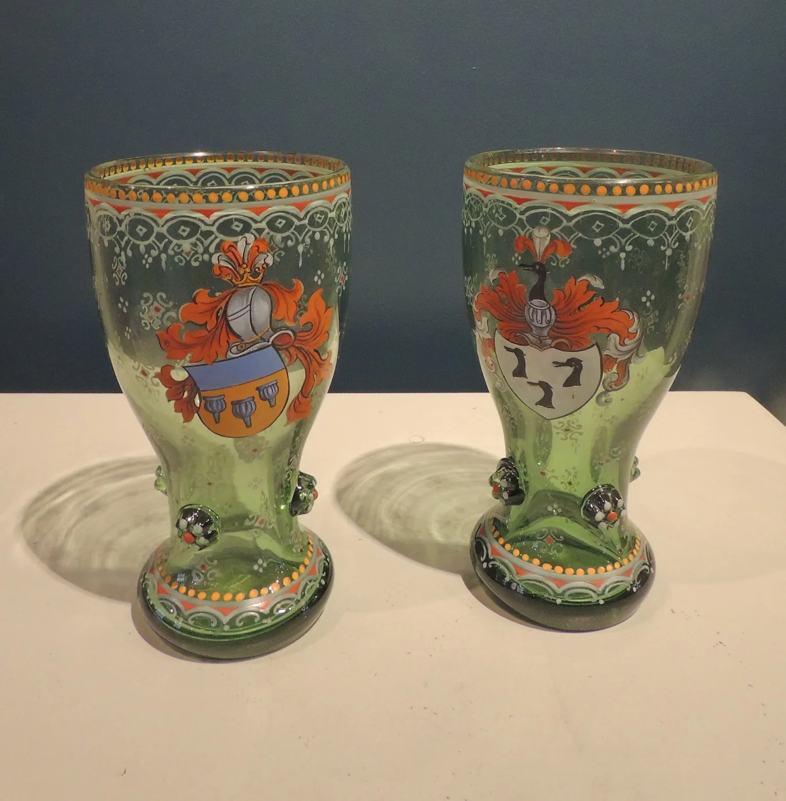 Pair of green glass glasses with heraldic decoration