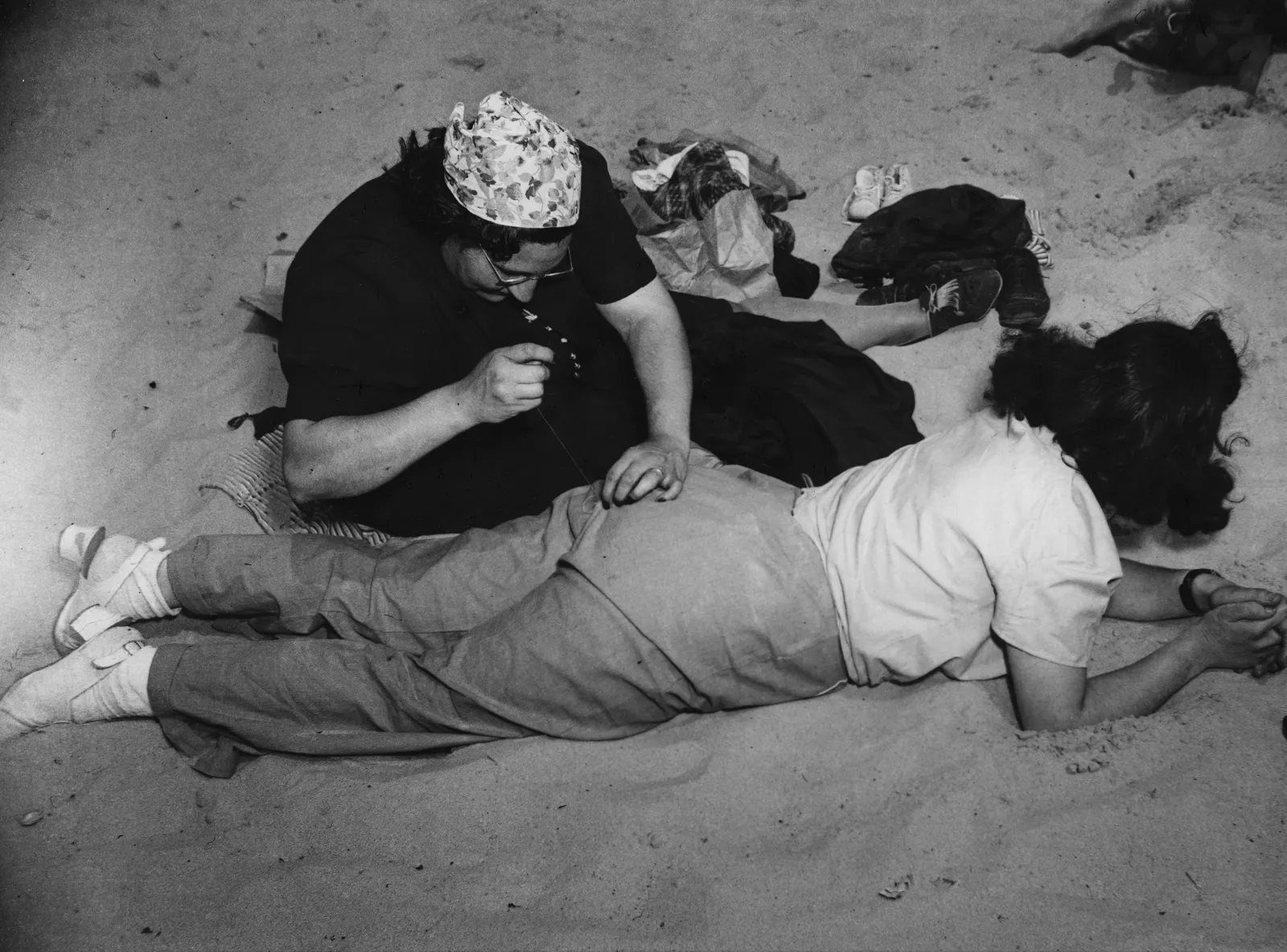 Weegee, Coney Island (Sewing Pants), 1940