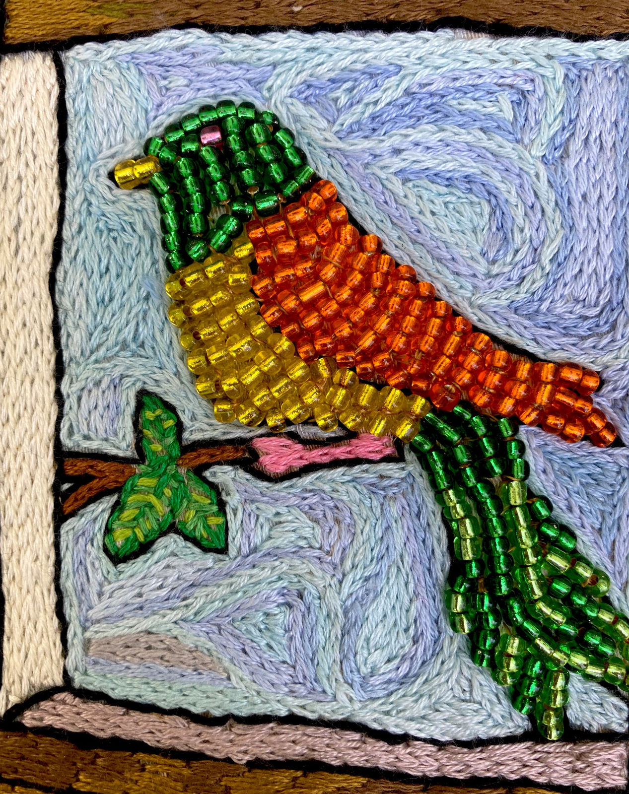 beaded image of bird in orange and green