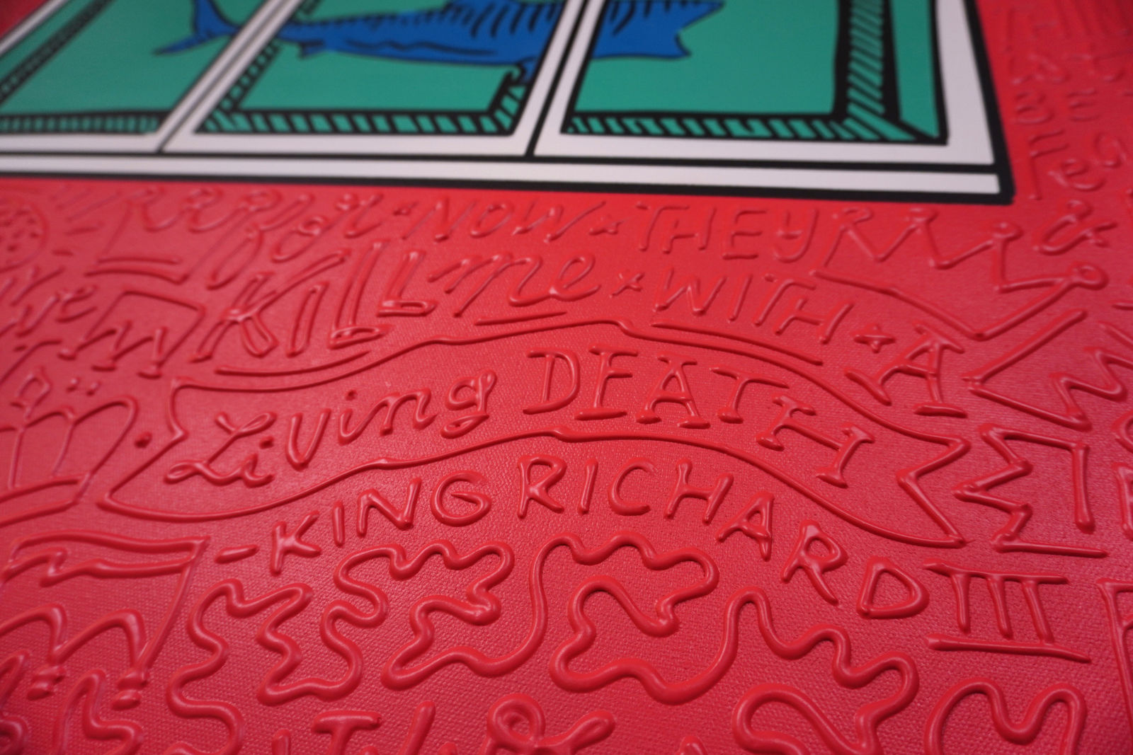 Detail photo of “El Tiburón”, painting by Cayla Birk artist from South Florida. Available at Carousel Fine Art Chicago. The artist’s technique blends traditional acrylic paints with unique materials, creating a distinct mixed media style. Birk's work is marked by intricate designs and recognizable gestures, combining contemporary culture, history, music, and literature. Her art challenges conventional thinking, offering new and unexpected experiences. Colors of this work : Red, Blue, Teal, Beige, White, Black