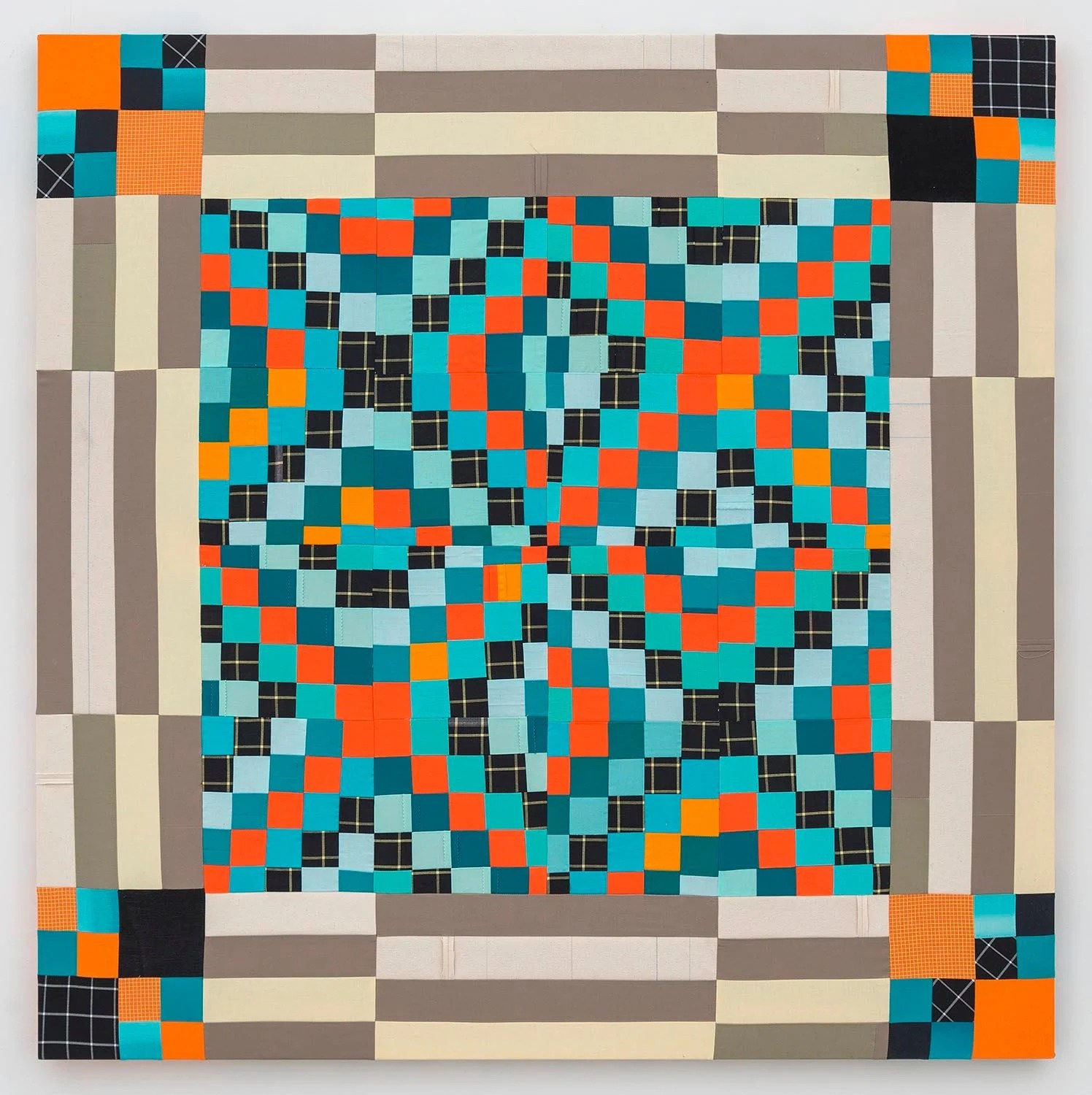 Square textile piece. In the center and corners are small squares in shades of orange, blue, and black and white grid alternating to form X patterns. Around the borders are stripes of brown, cream, and tan.