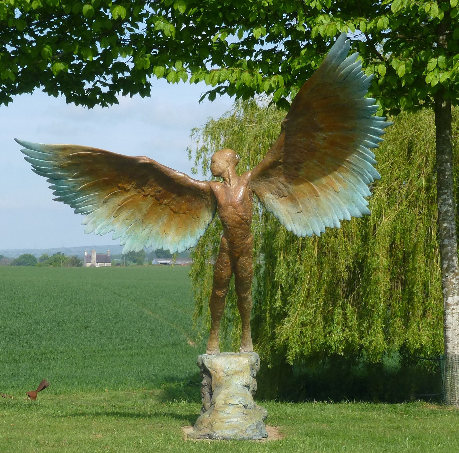 Bronze resin sculpture of mythical Greek winged figure Icarus by Nicola Godden, displayed on integral stone plinth