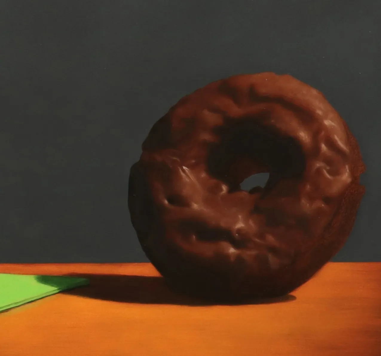 Silver golf trophy on green napkin in swing towards chocolate covered donut