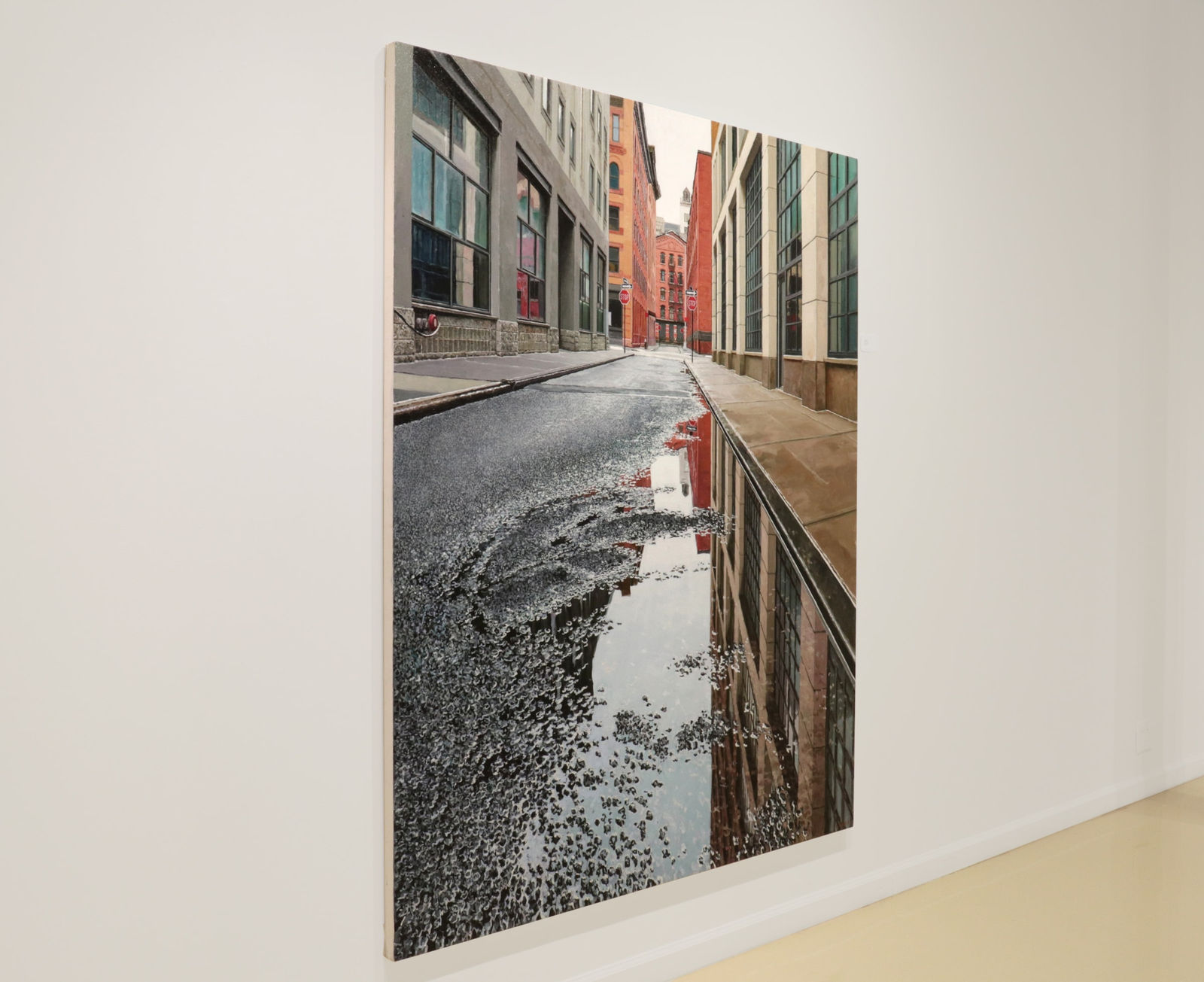 View from ground of puddle on Collister street reflecting grey sky