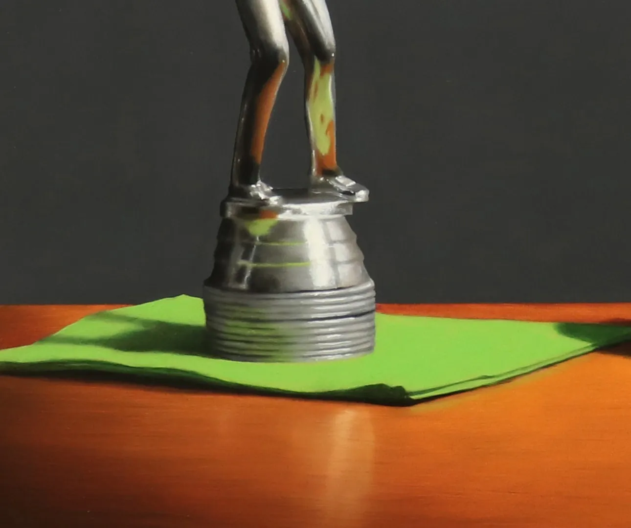 Silver golf trophy on green napkin in swing towards chocolate covered donut