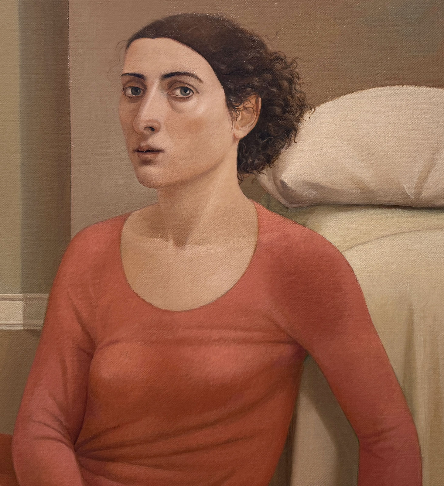 Man in a blue shirt and a woman in a red dress sitting on a bedroom floor