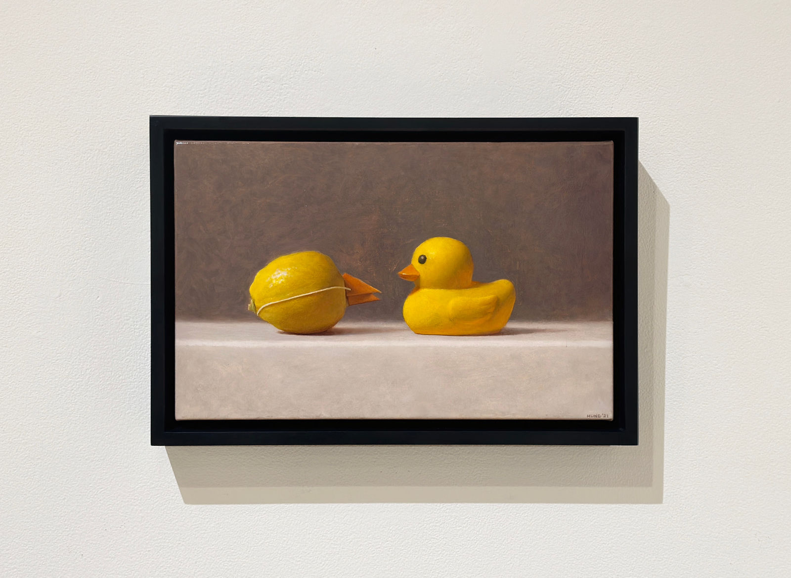 Lemon with paper beak faces a rubber duck