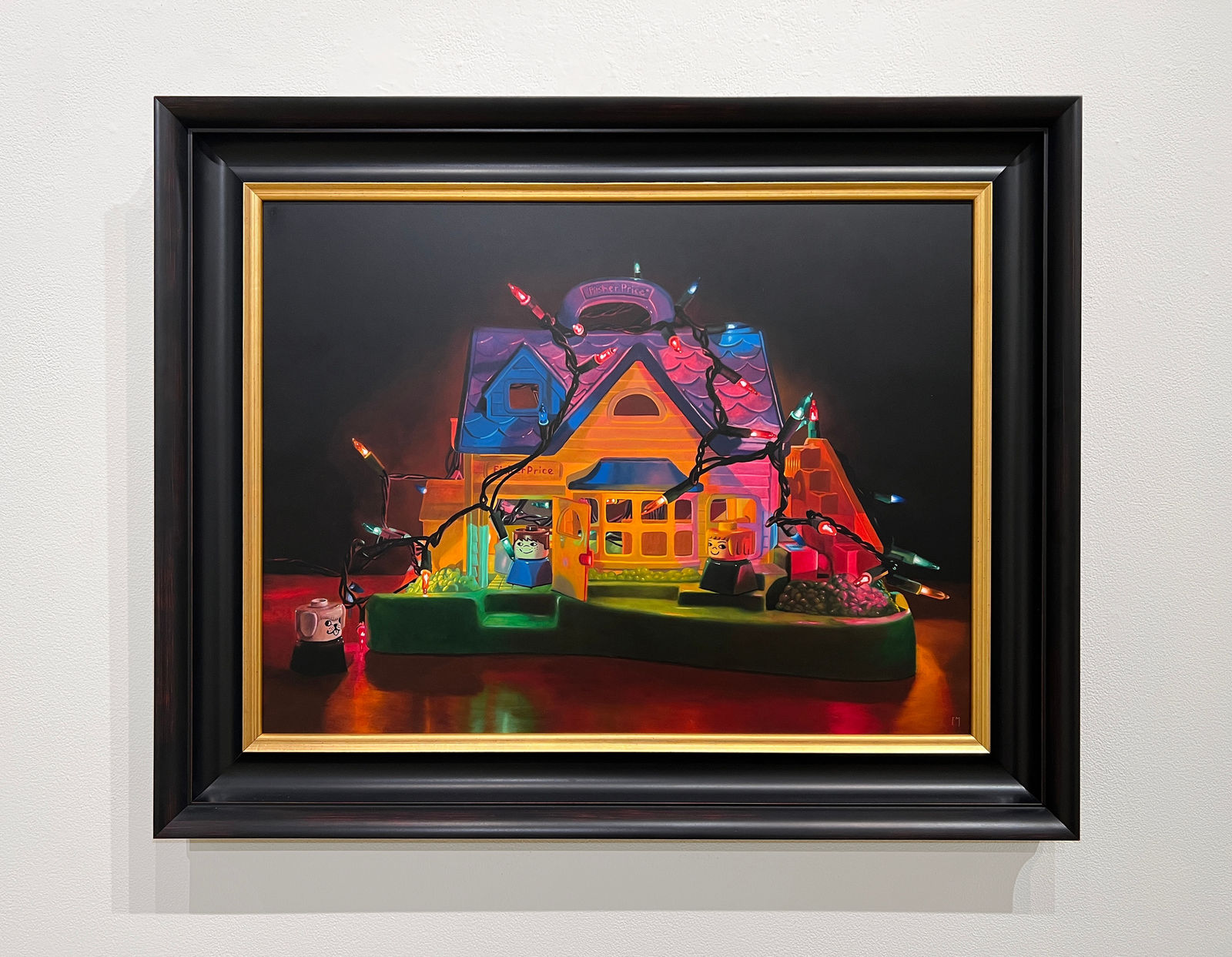 A Fischer Price Play house is wrapped and filled with a strand of colored lights with different Fischer Price toy characters placed in and around the house