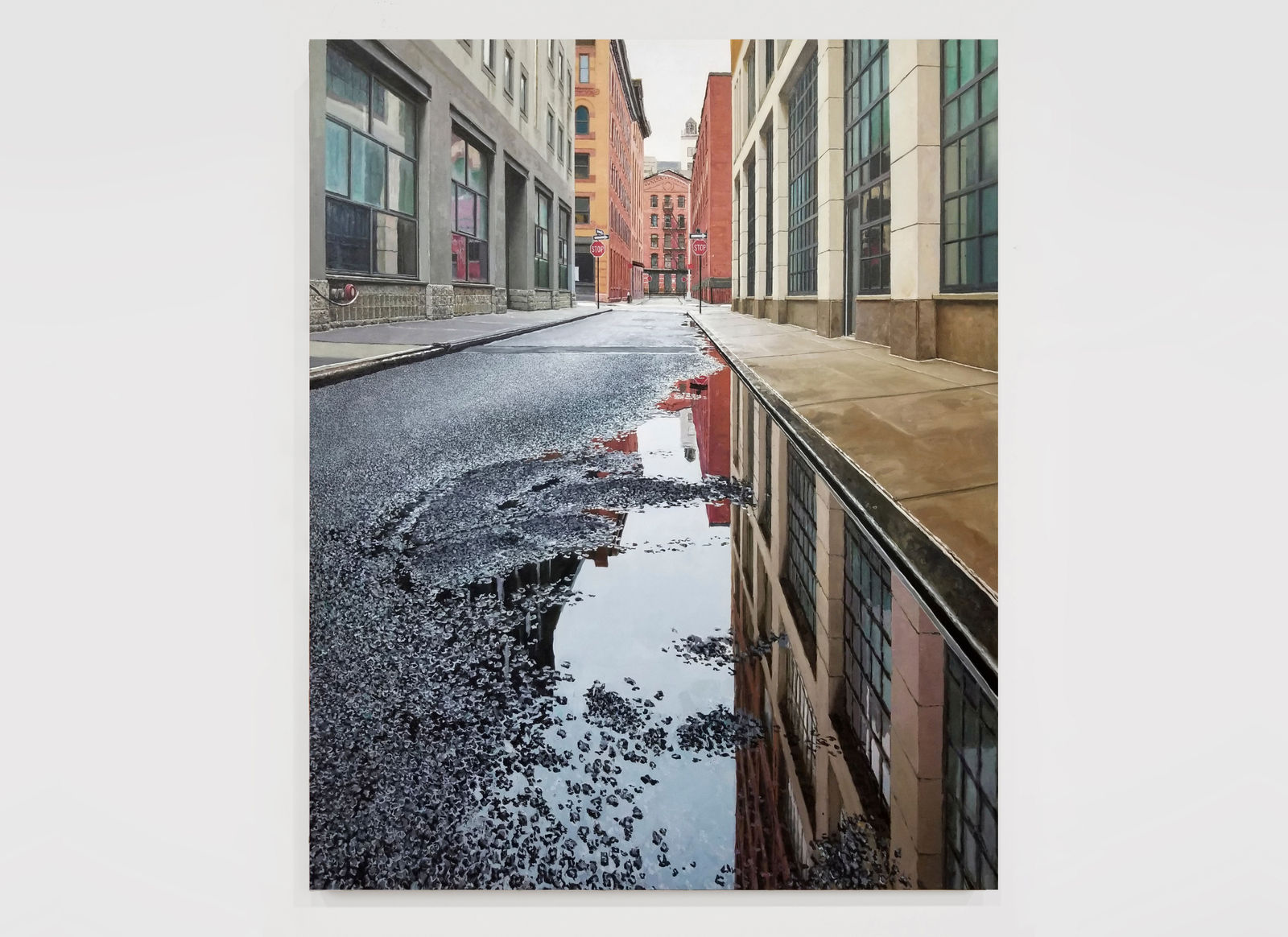 View from ground of puddle on Collister street reflecting grey sky