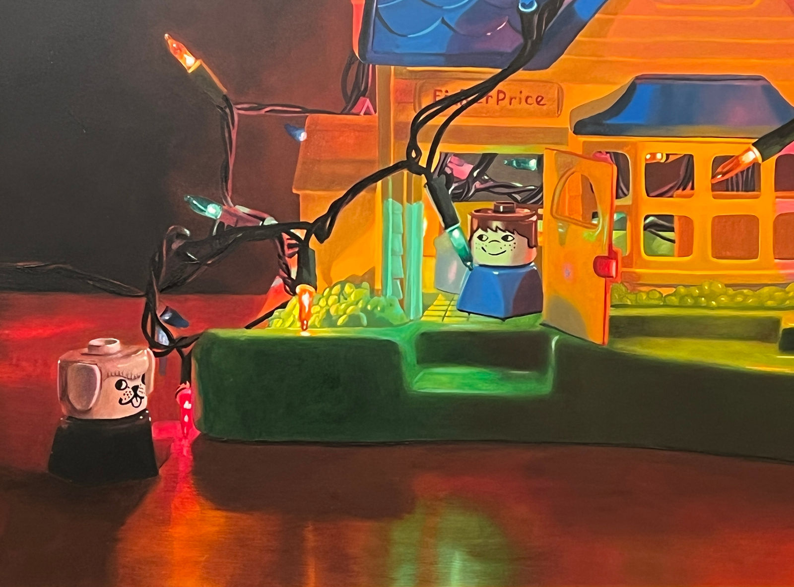 Detail of A Fischer Price Play house is wrapped and filled with a strand of colored lights with different Fischer Price toy characters placed in and around the house