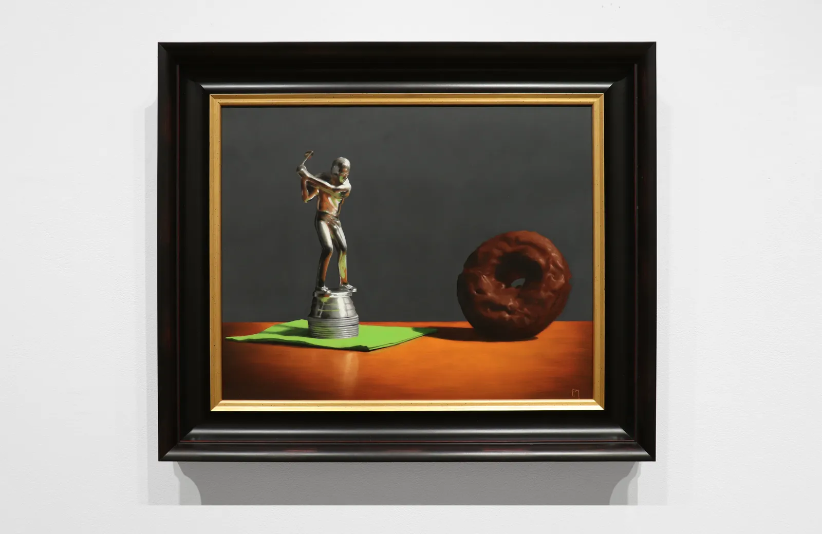 Silver golf trophy on green napkin in swing towards chocolate covered donut