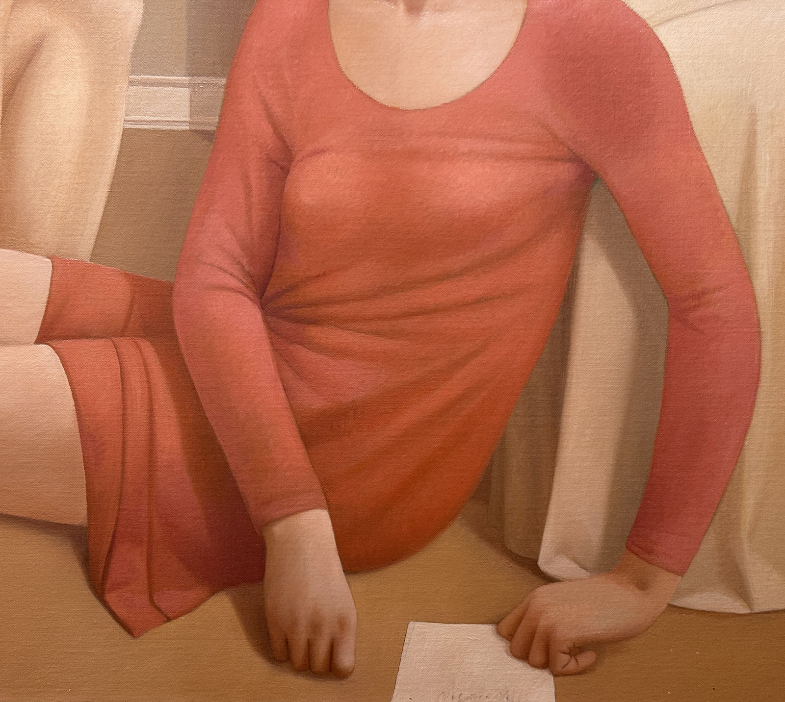 Man in a blue shirt and a woman in a red dress sitting on a bedroom floor