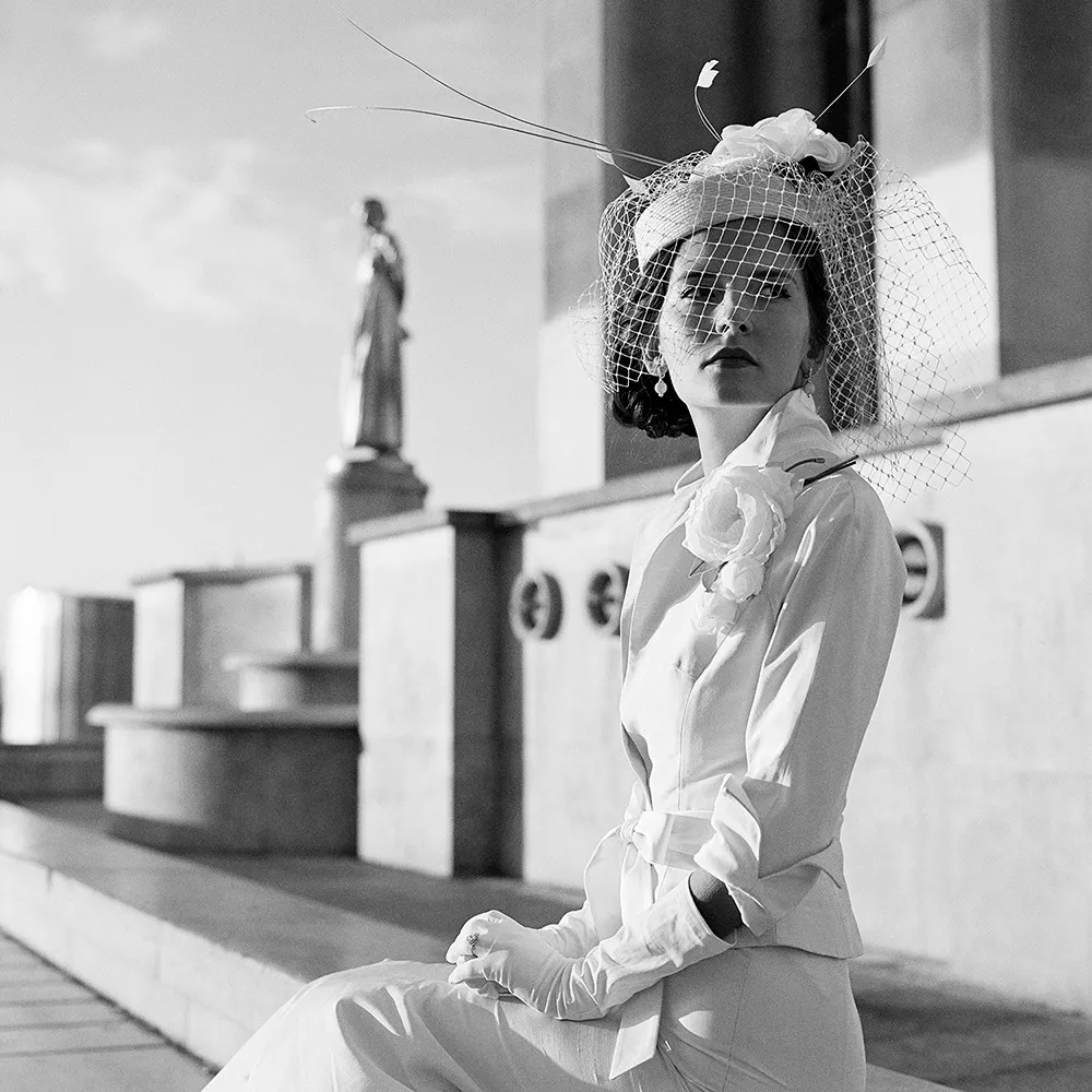 fashion photograph woman seated in the Trocadaro, Paris France wearing white suite