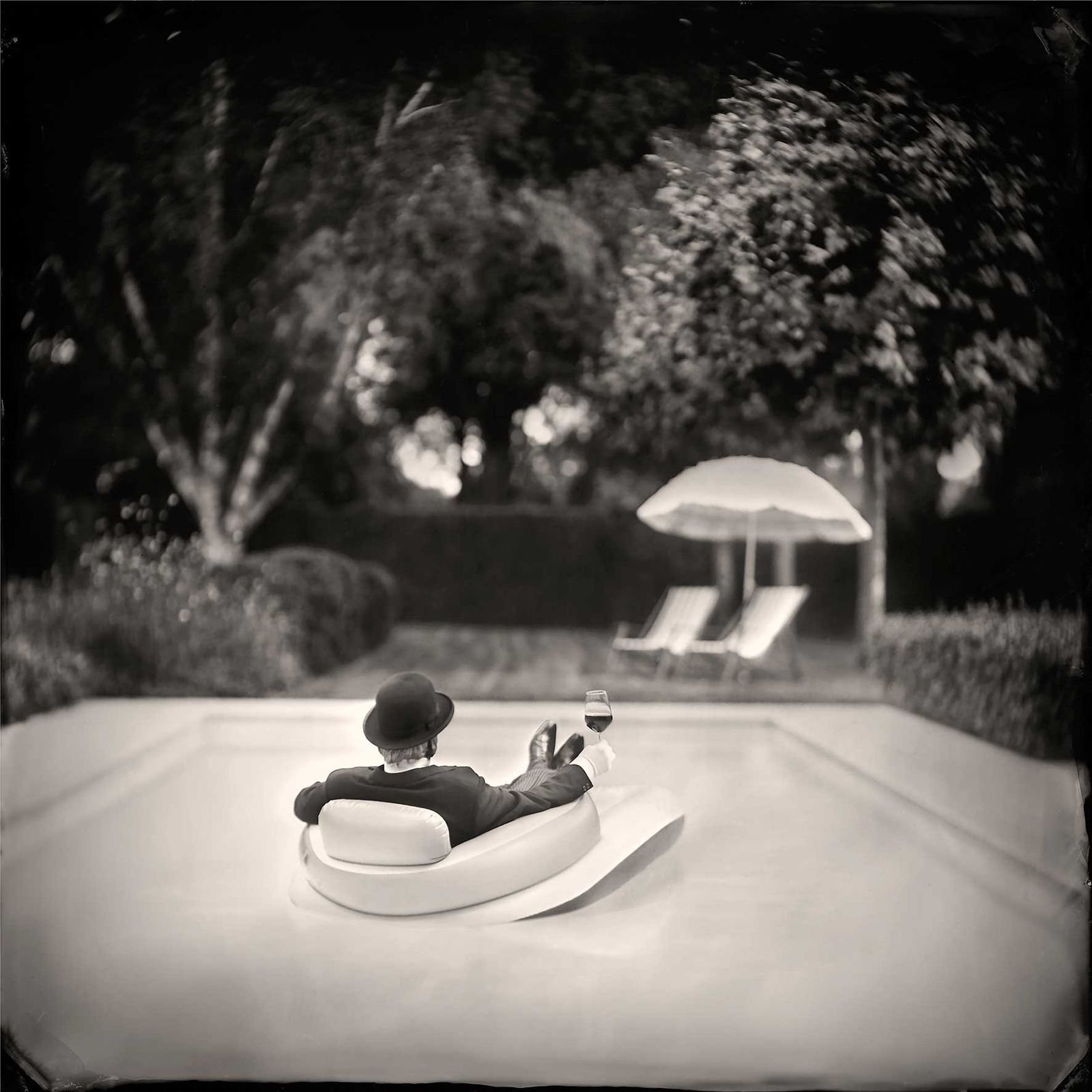 Alex Timmermans photography butler floating in pool chair with a glass of wine buy Me Time here Gilman Contemporary Sun Valley art gallery