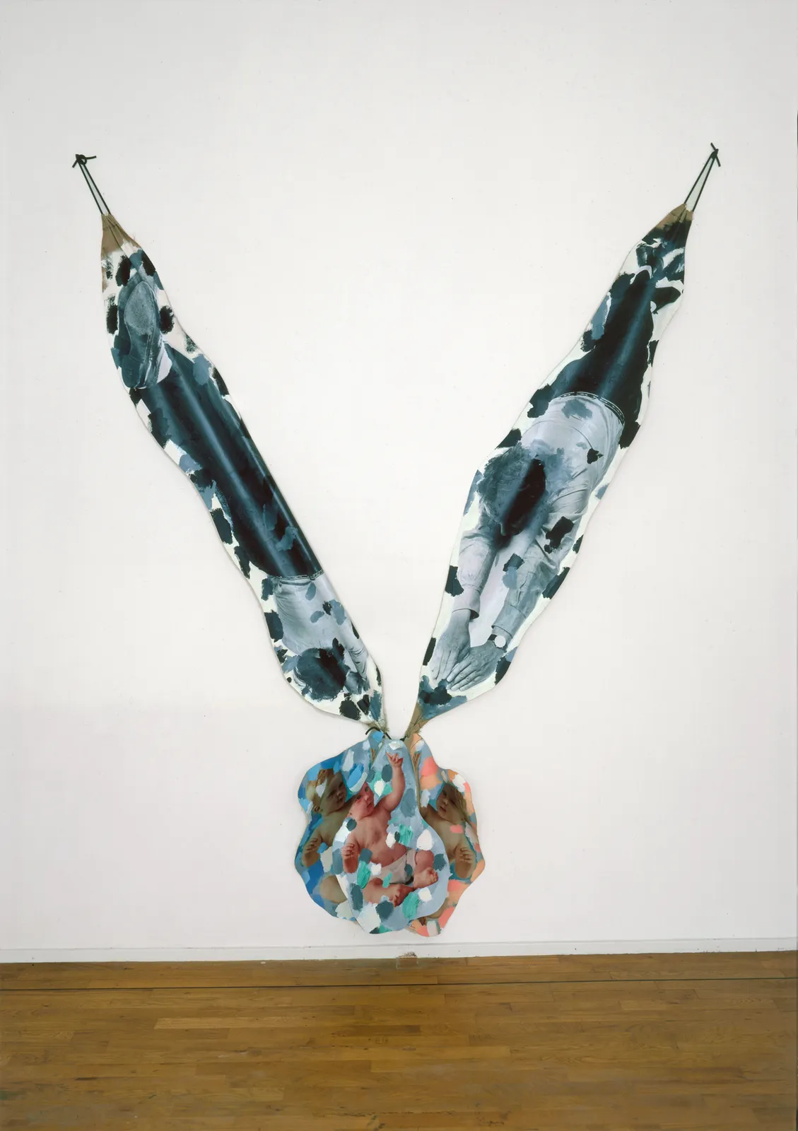A mixed media piece resembling bird feathers attached to a ball.