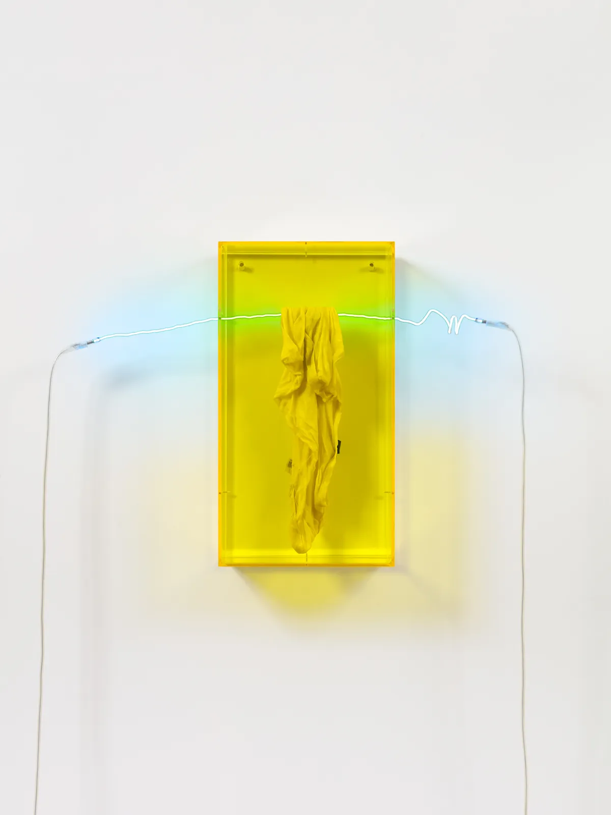 A wax cloth suspended by a green neon rod encased within a yellow plexiglass box.