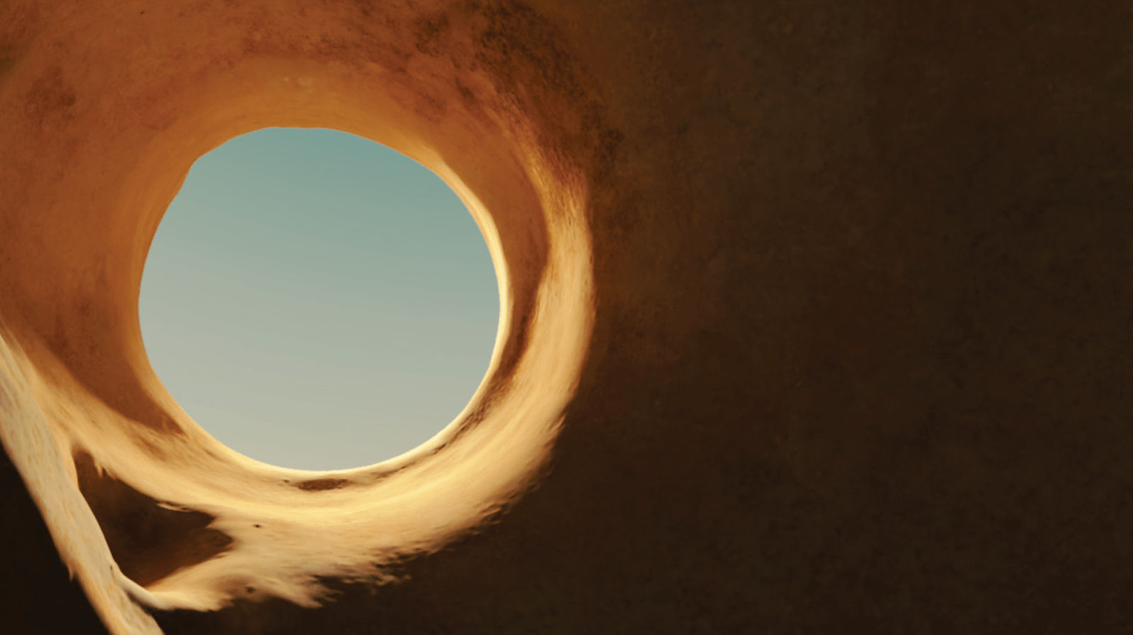 A photograph of a hole in what appears to be a desert rock formation