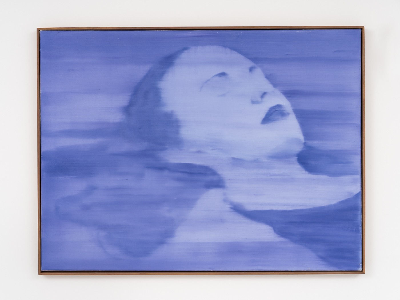 a deep indigo image that depicts a woman with her eyes closed floating in water