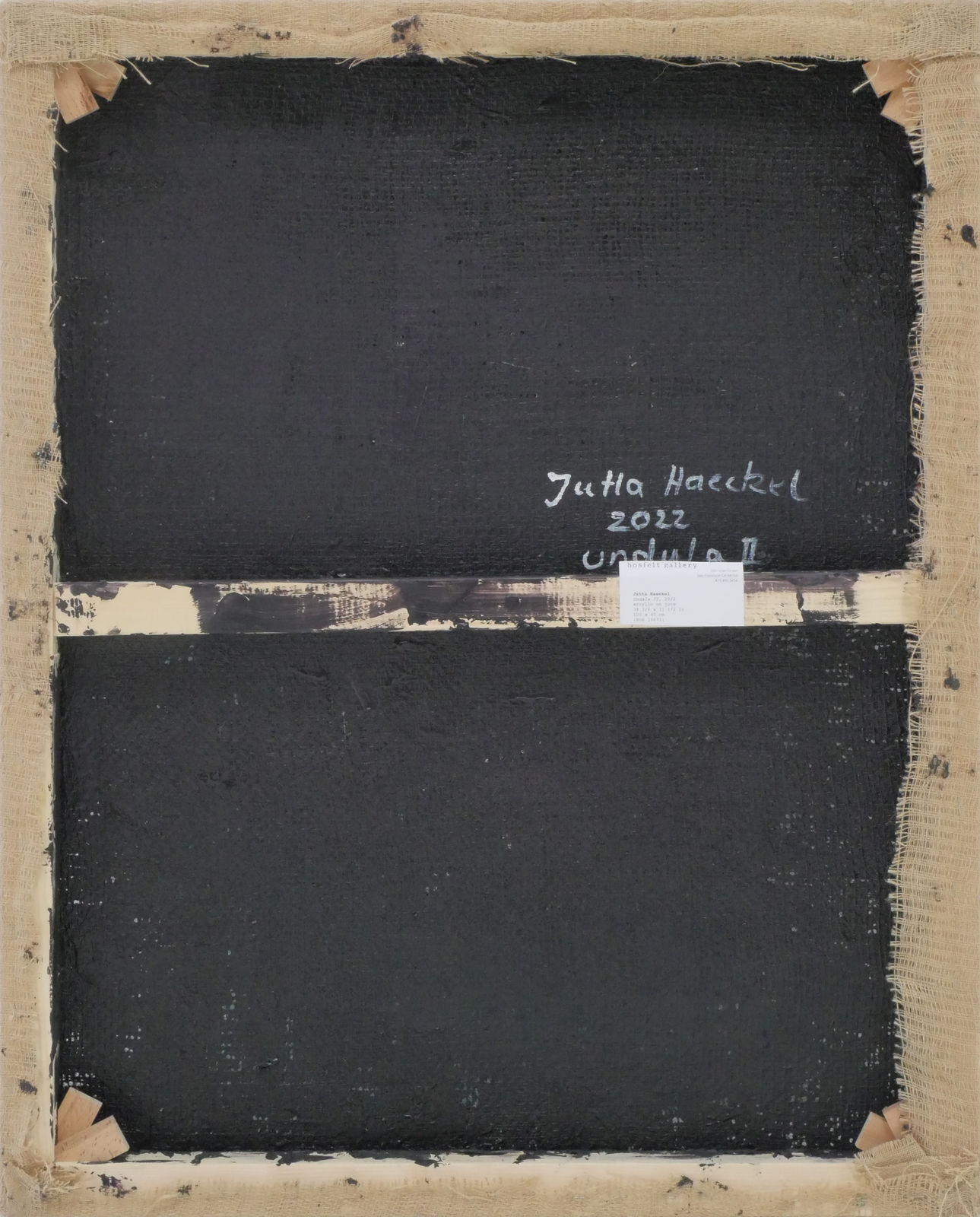 Backside of painting showing black paint applied to the canvas, with artist signature, year, and piece title.