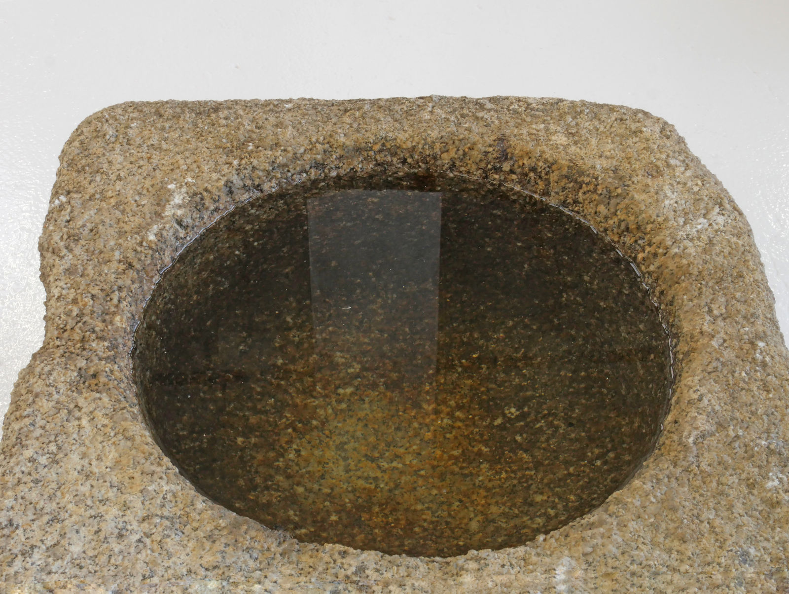 Closer detail view of top of weather stone basin, looking into bowl of basin.