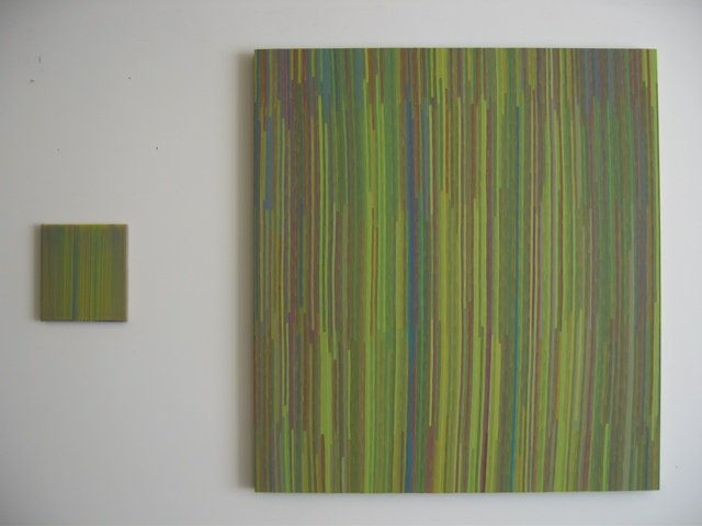 Two green red yellow and blue striped painted panels follow the same pattern The panel to the right is a large rendition of the color pattern while the one on the left is much smaller