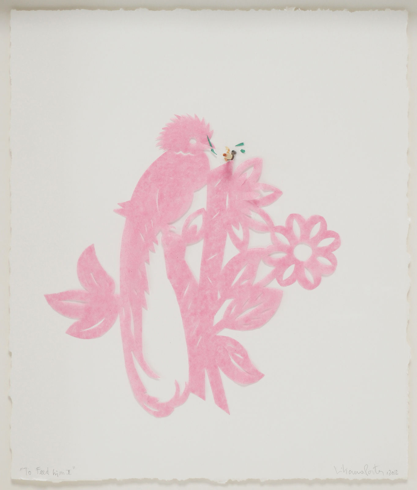 A pattern of a quetzal perched on top of a floral tree branch cut out of pink tissue paper. The pink tissue paper pattern is mounted on a white piece of paper. On top of the papers a tiny human figurine kneels down and appears to be feeding the pink quetzal strips of green tissue paper