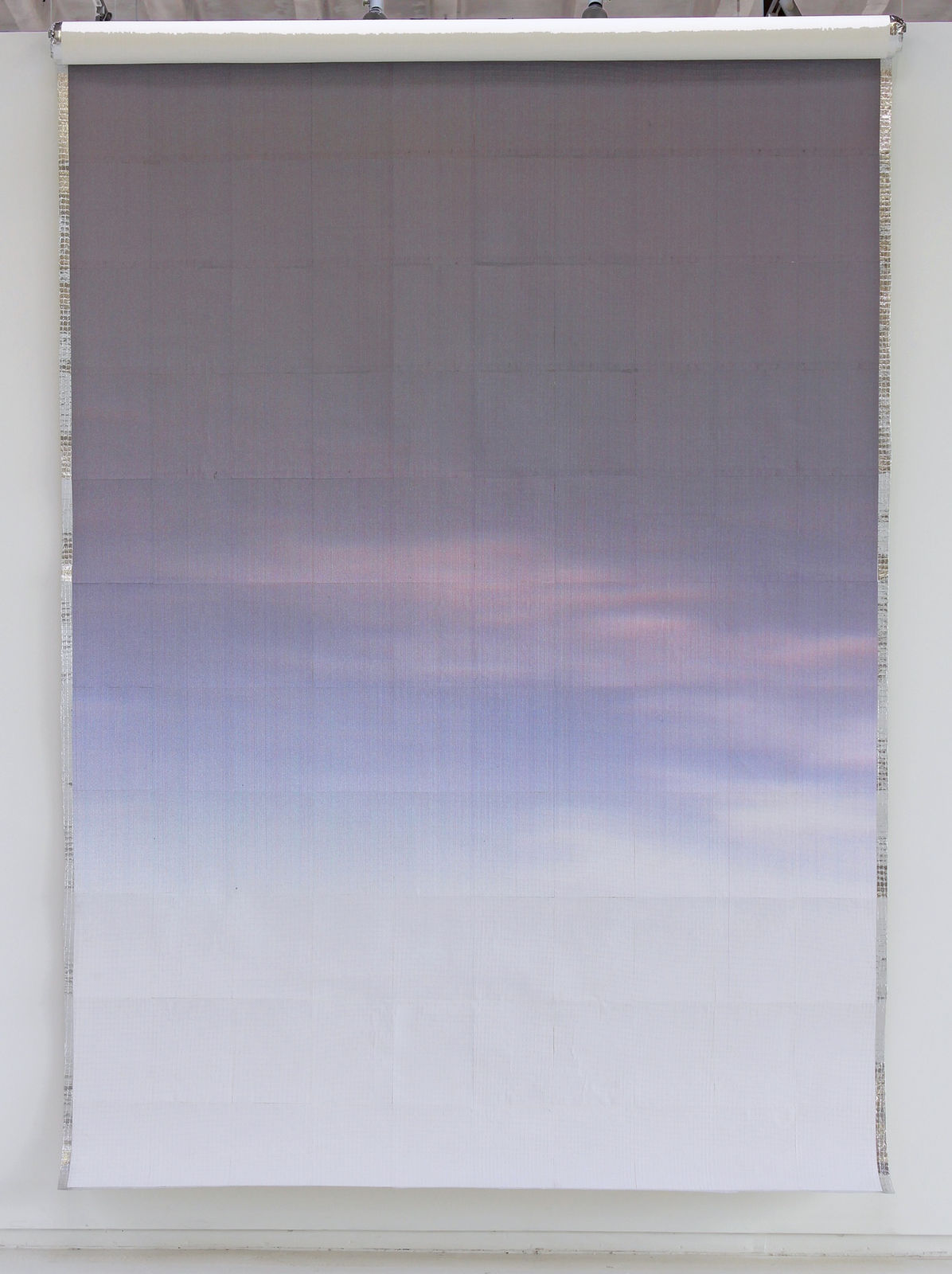 Printed paper of a purple and blue sunrise with faint thin clouds against aluminum foil