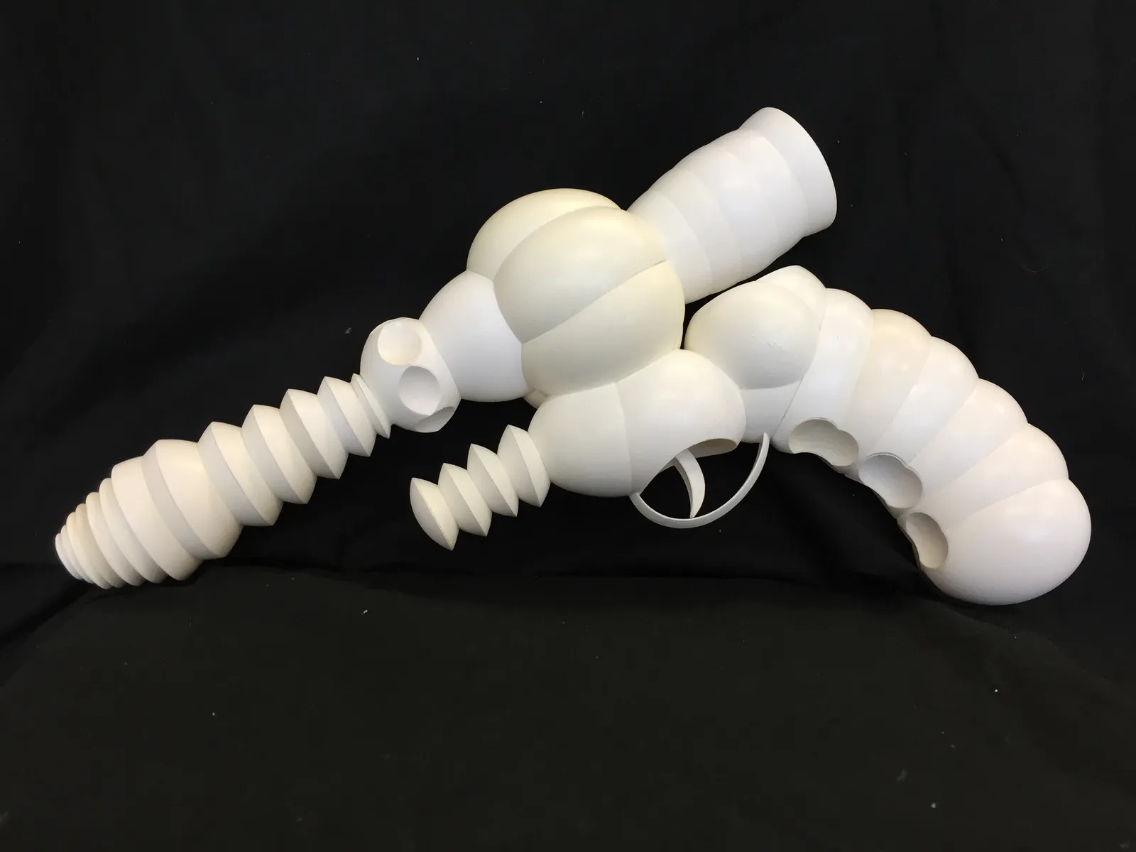 Carved and layered white eggshells create a sculpture of a sci-fi ray gun