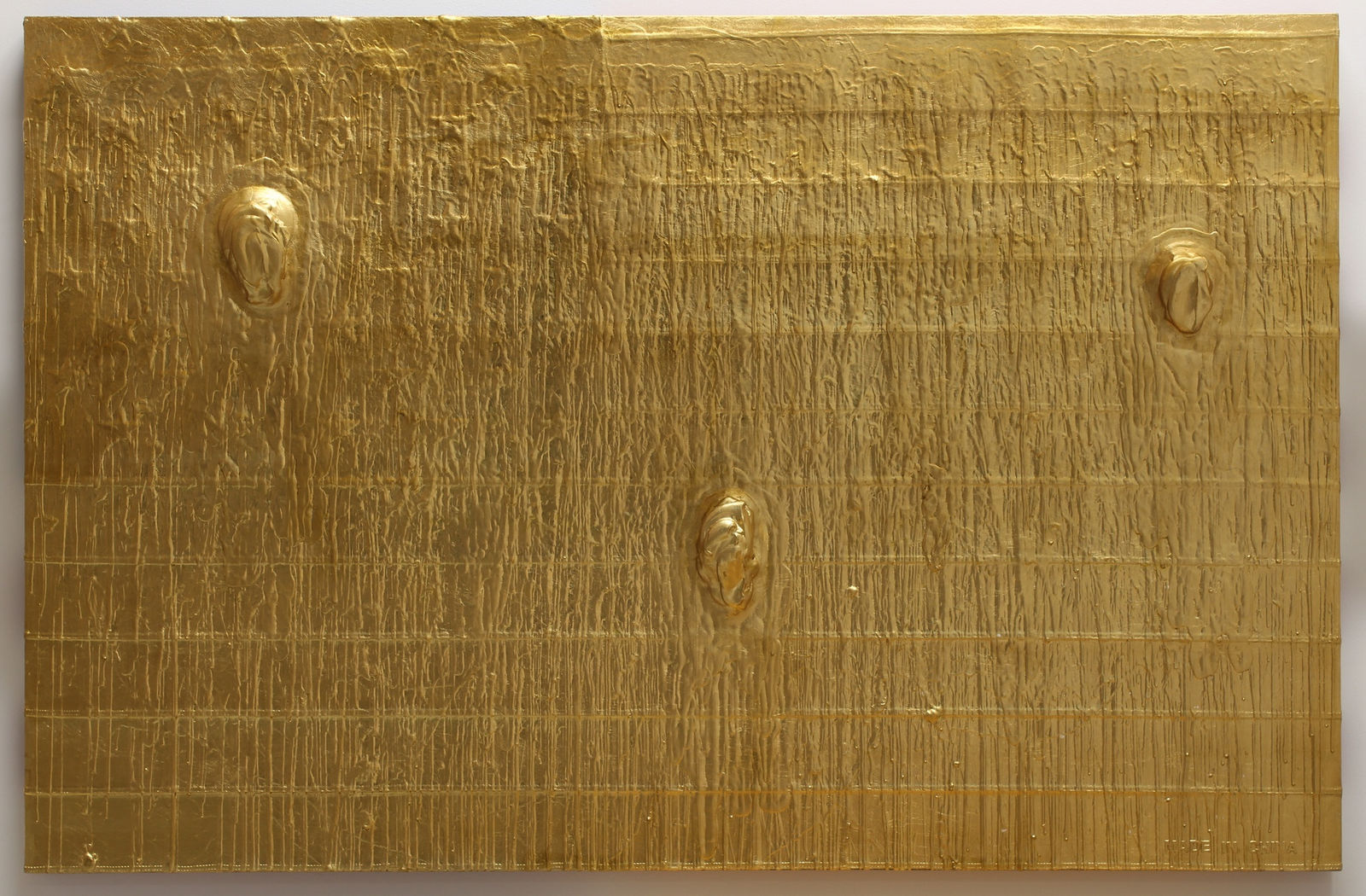 Outline of an American flag barely visible underneath a thick layer of gold-leaf. Three glops of gold paint stick out from flag.