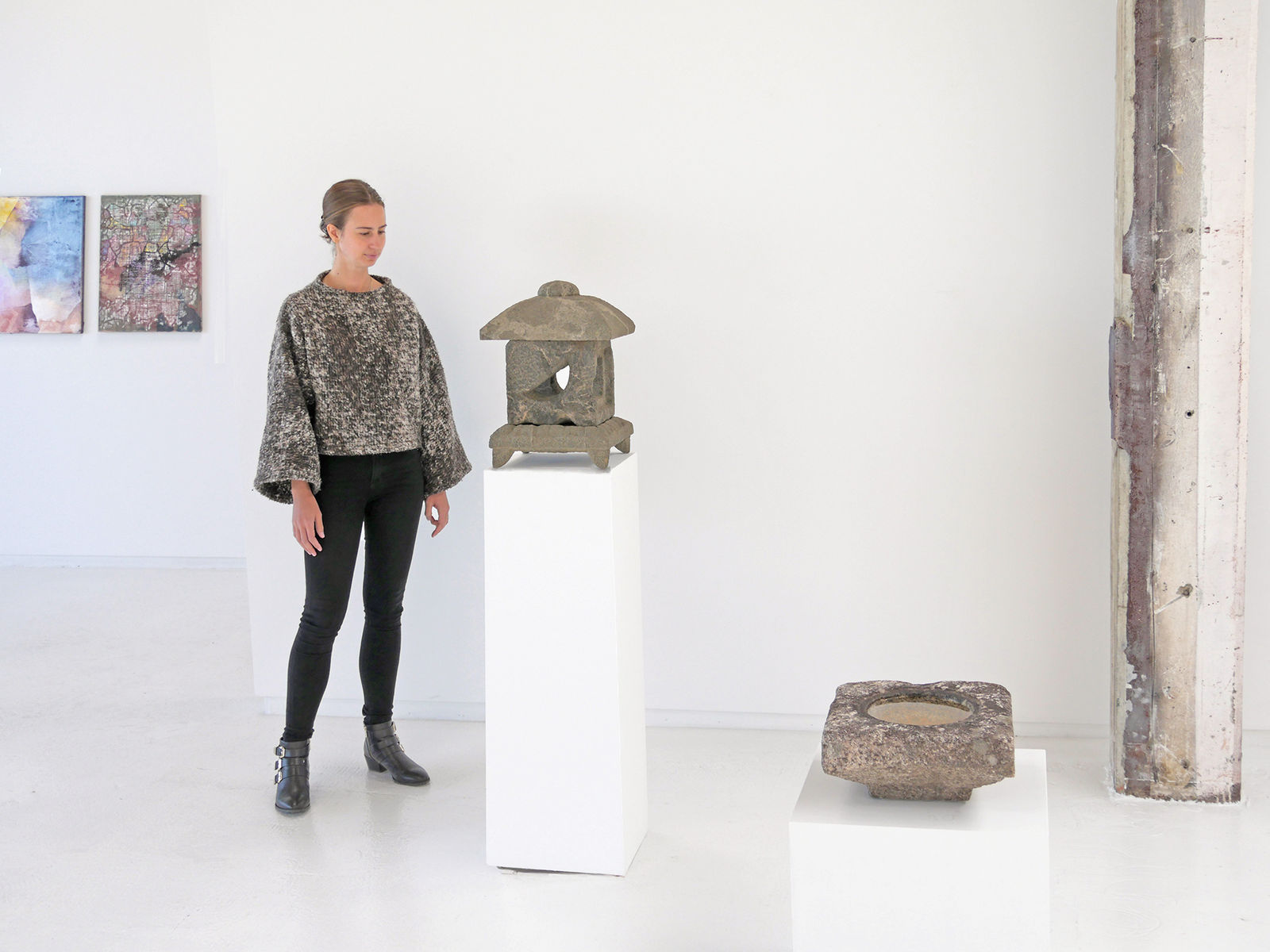 Woman standing with stone sculpture.