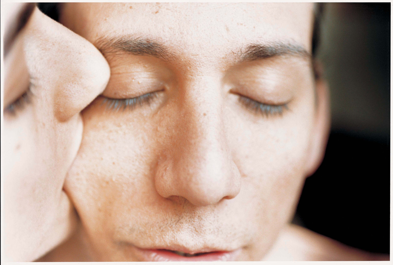 Elinor Carucci close up photograph of the artist kissing her husband on the cheek