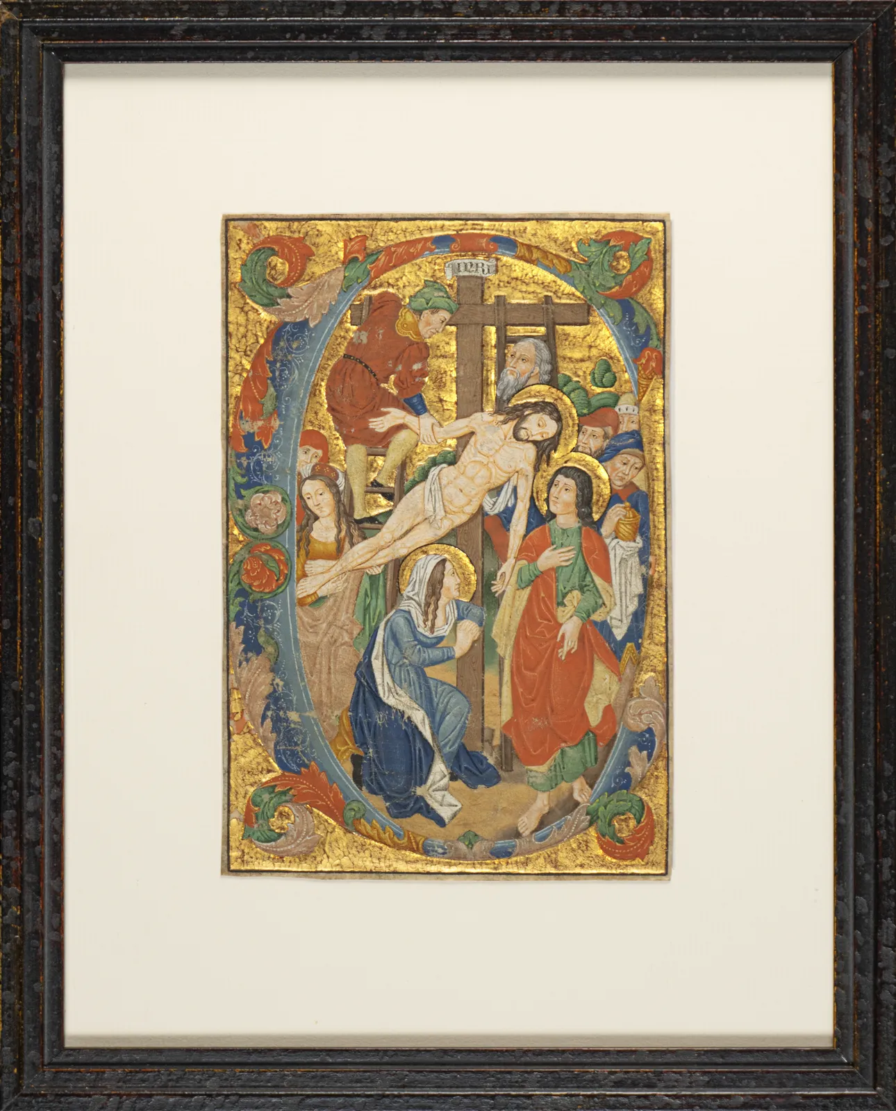 Framed artwork of the Deposition from the Cross in the style of a medieval miniature by the Spanish Forger, featuring gold-leaf gilding and vivid pigments on parchment, early 20th century.
