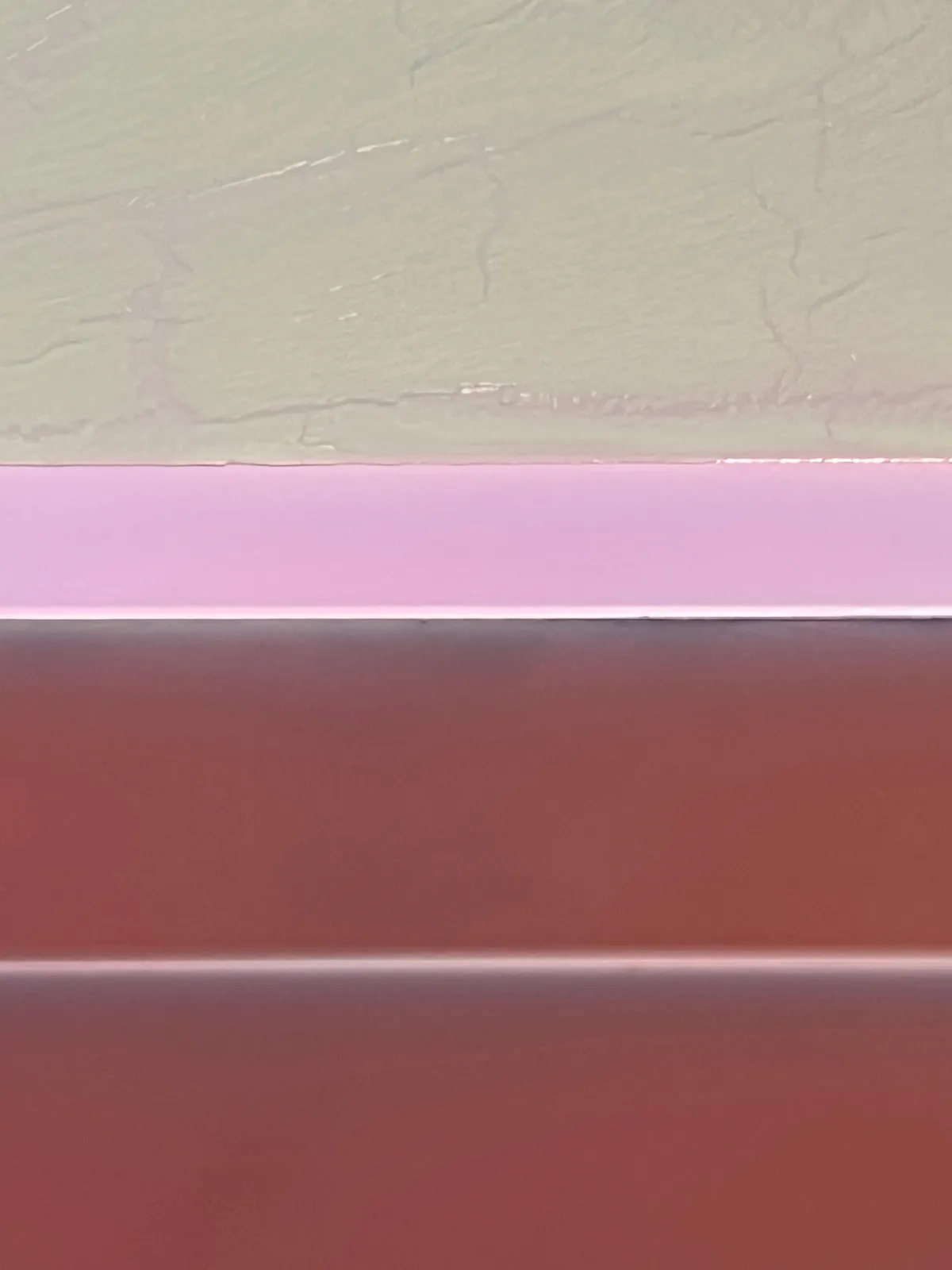 abstract work made of horizontally aligned segments in desaturated tones of red, pink, and green