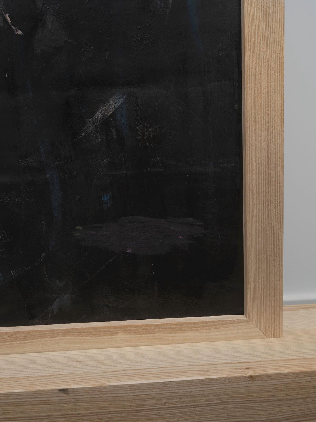 Partial view of reverse T-shaped freestanding painting with a wooden frame and base and abstract pink and faded blue crayon marks on a dark background, against a white wall Rindon Johnson Paths wind through woods. Dogs chase their tails. Smiles light up faces. Laughs echo loudly. Dreams take flight. Hopes rise high. Waves roll gently. Children skip merrily. Words convey thoughts. Maroon. Time heals wounds. Minds seek answers. Fates twist and turn. Truths reveal slowly. Lives unfold daily. Manifestation is such a chore. Say it a loud, see it how mouths: a companionable environment can engender impressive thirstiness, 2023 Ash wood, leather, crayon, oil, colored pencil, acrylic and wax 188.5 x 100 x 24.5 cm 74 1/4 x 39 3/8 x 9 5/8 inches