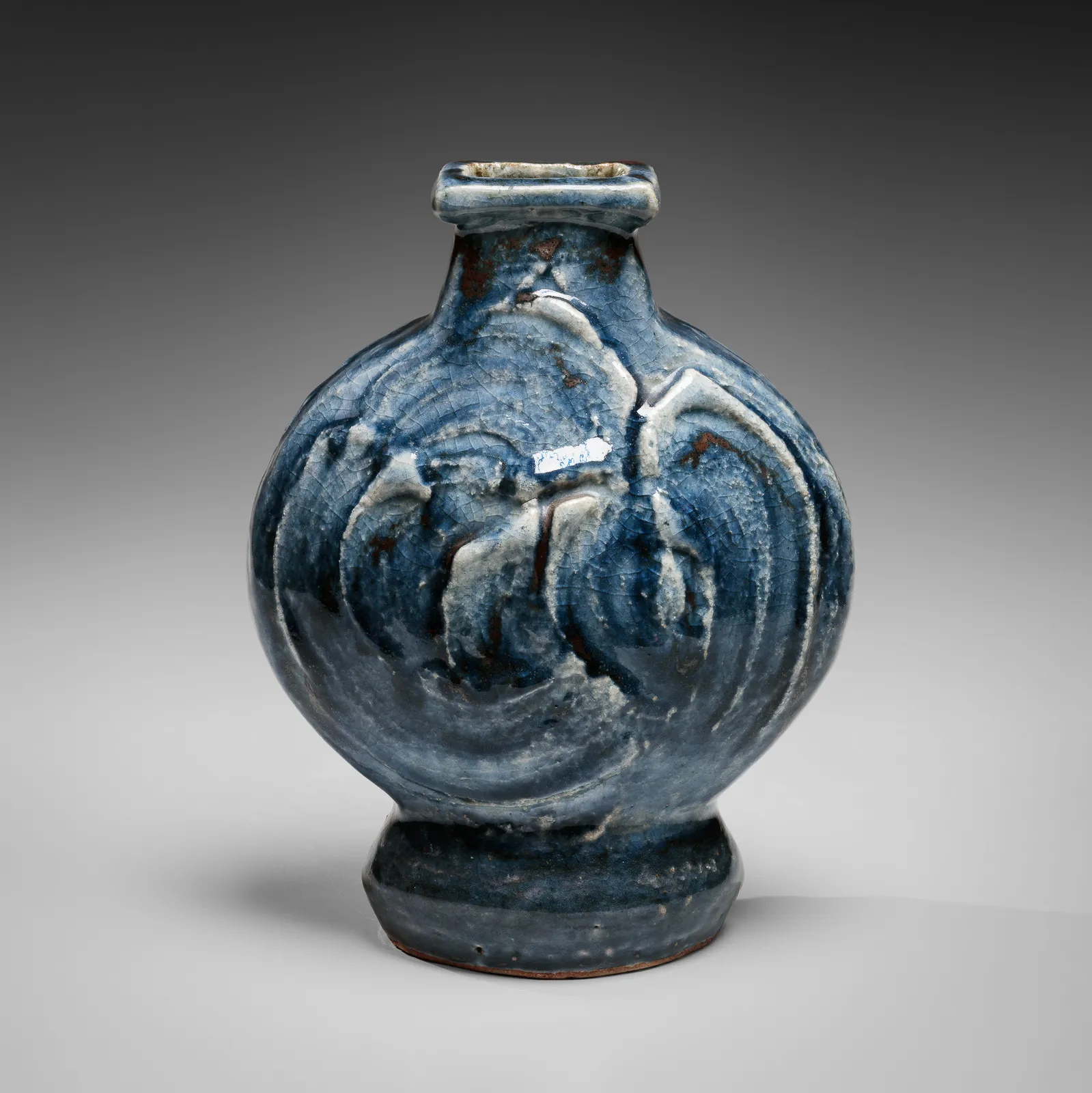 KAWAI KANJIRŌ, Cobalt-glazed (gosu) flattened circular vessel with raised rectangular mouth and carved decoration, ca. 1950s-60s