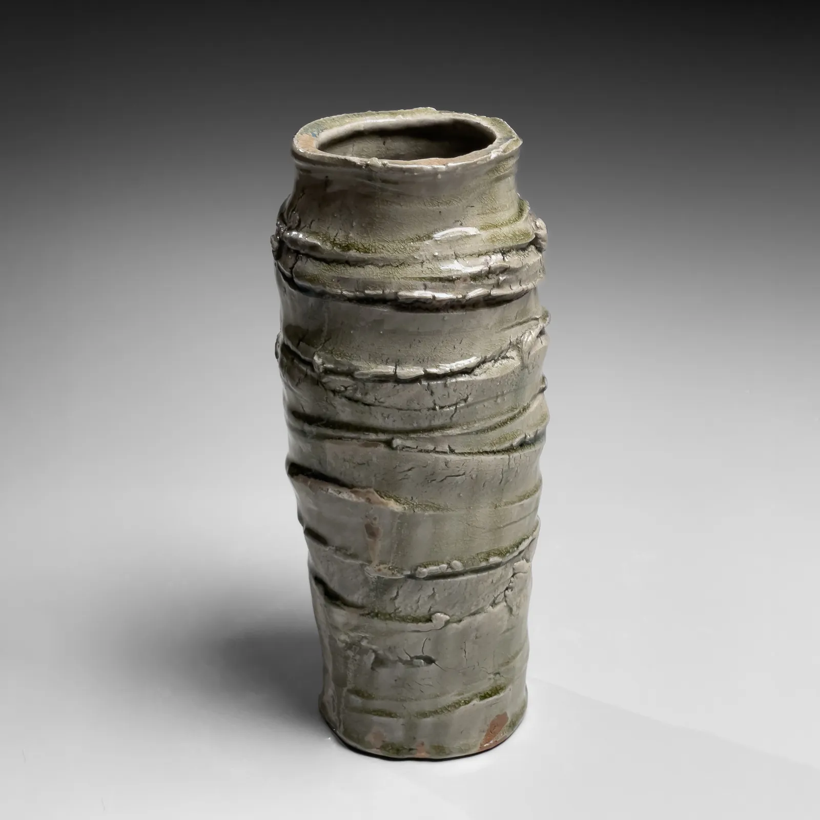 OKABE MINEO, Ash-glazed columnar vessel with irregular carved banding, 1963