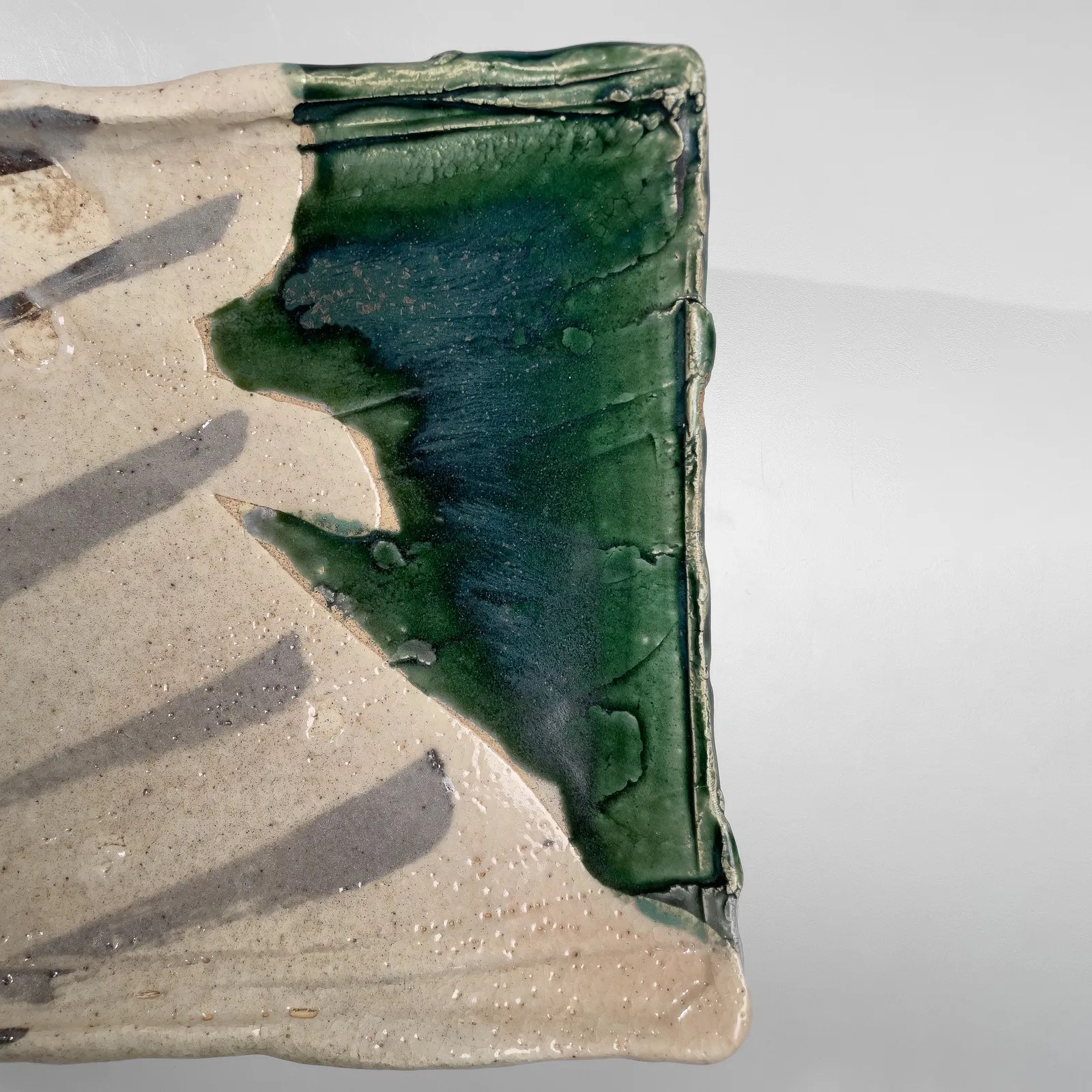 OKABE MINEO, Shino and Oribe-glazed rectangular platter with four feet, 1965